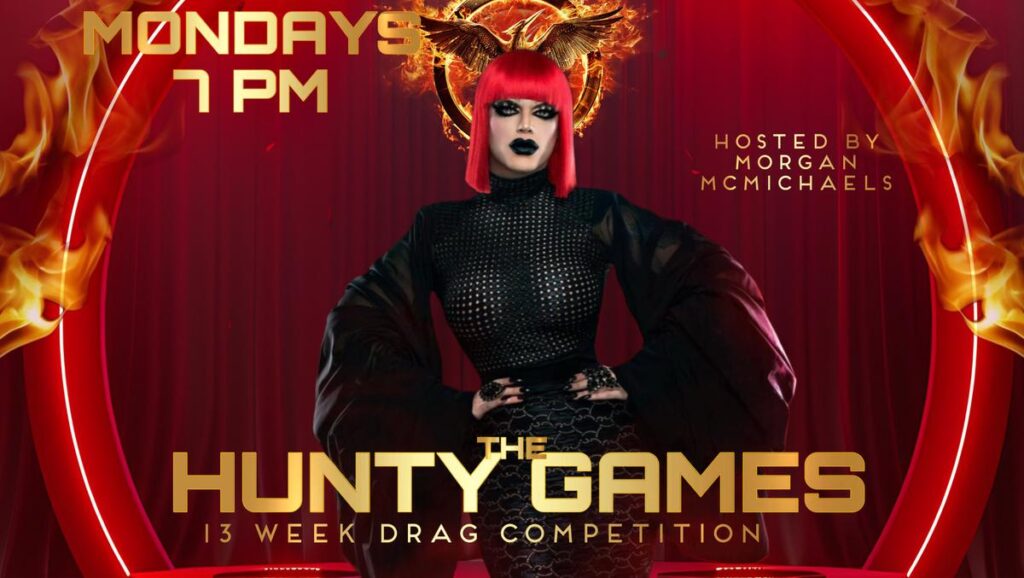 A promotional poster for "The Hunty Games" at Micky's West Hollywood. The poster features a drag queen with a red wig and a black outfit against a red background with flames. The text includes "MONDAYS 7 PM", "HOSTED BY MORGAN MCMICHAELS", and "THE HUNTY GAMES 13 WEEK DRAG COMPETITION".