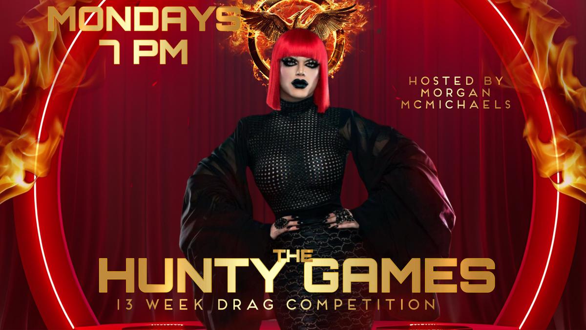 A promotional poster for "The Hunty Games" at Micky's West Hollywood. The poster features a drag queen with a red wig and a black outfit against a red background with flames. The text includes "MONDAYS 7 PM", "HOSTED BY MORGAN MCMICHAELS", and "THE HUNTY GAMES 13 WEEK DRAG COMPETITION".