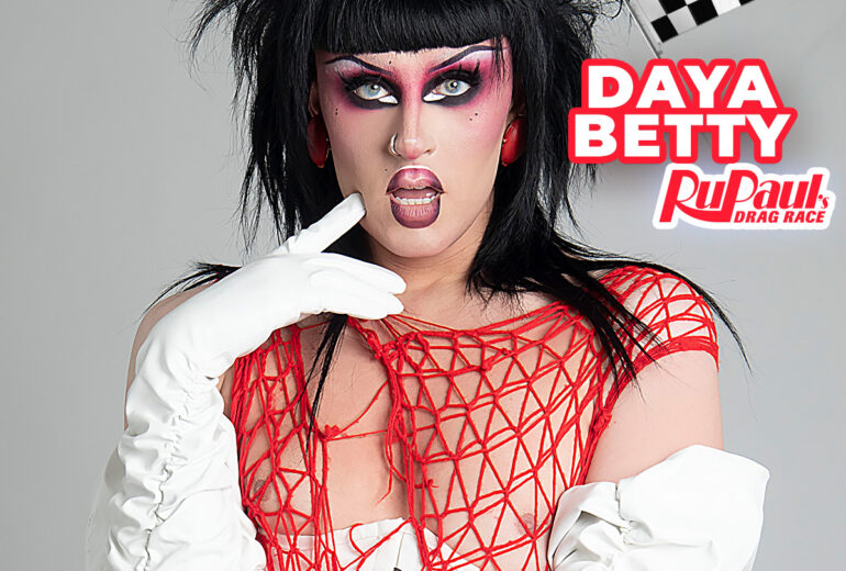 Promotional poster for a performance by Daya Betty at Micky's West Hollywood on Friday, November 21st at 8 PM featuring Daya Betty in full drag makeup and attire with a dramatic black hairpiece and red woven outfit, set against a vivid background with racing checkered flags. Located at 8857 Santa Monica Blvd, West Hollywood, CA 90069.